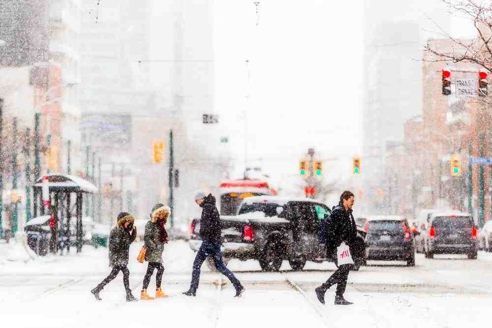 people walking on snow covered road during daytime